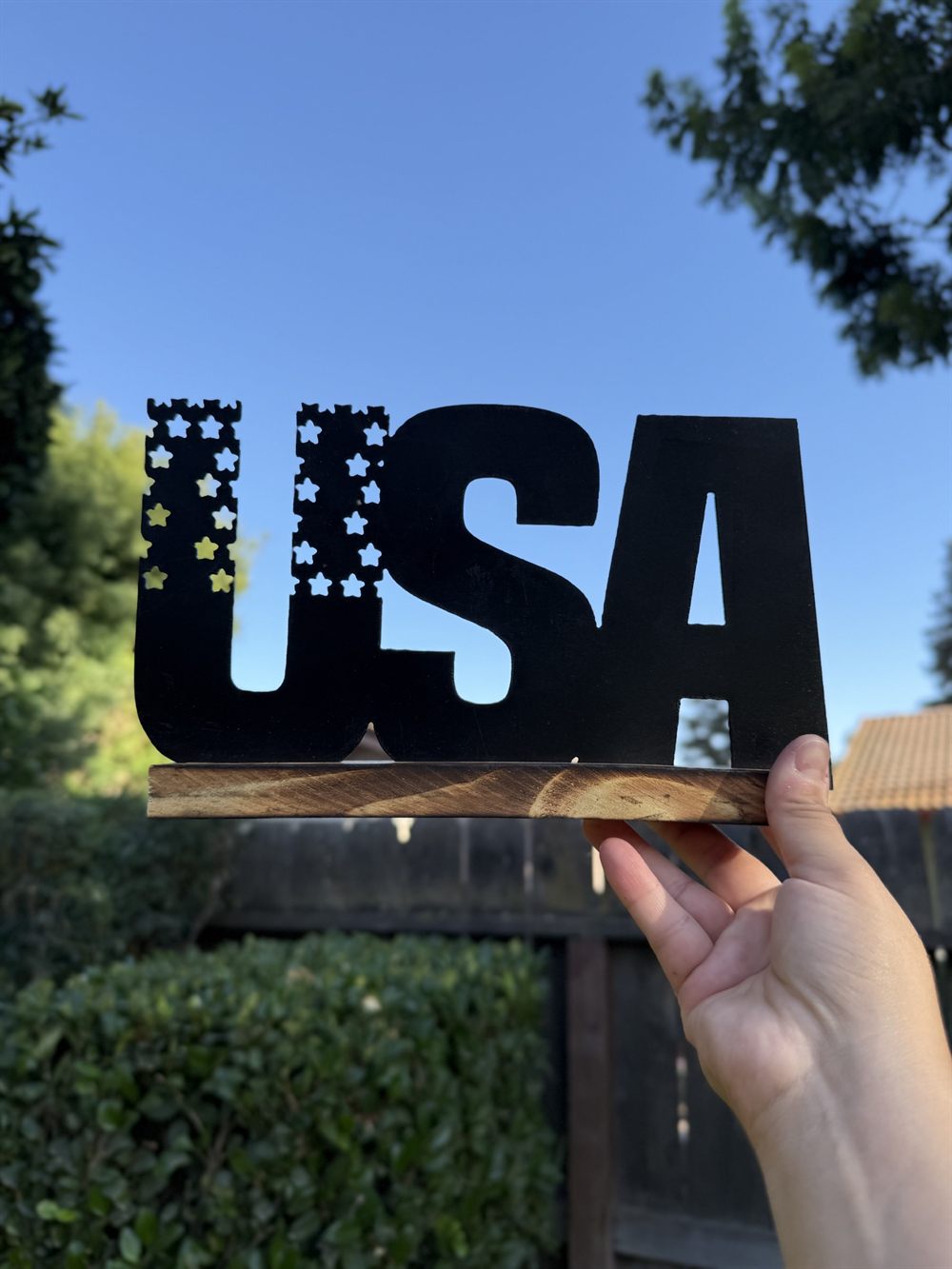 The letters USA cut from steel with a star-cut flag.