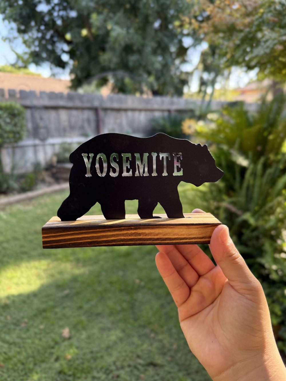 A steel bear with Yosemite cut through it, on a wood base.